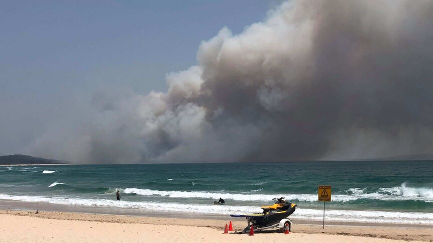 Large plumes of smoke can be seen over the horizon at Noosa North Shore.