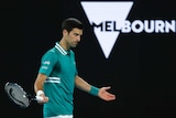 Novak Djokovic as his arms outsretched during his first-round match at the Australian Open.