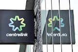 A centrelink sign with on a building with a reflection