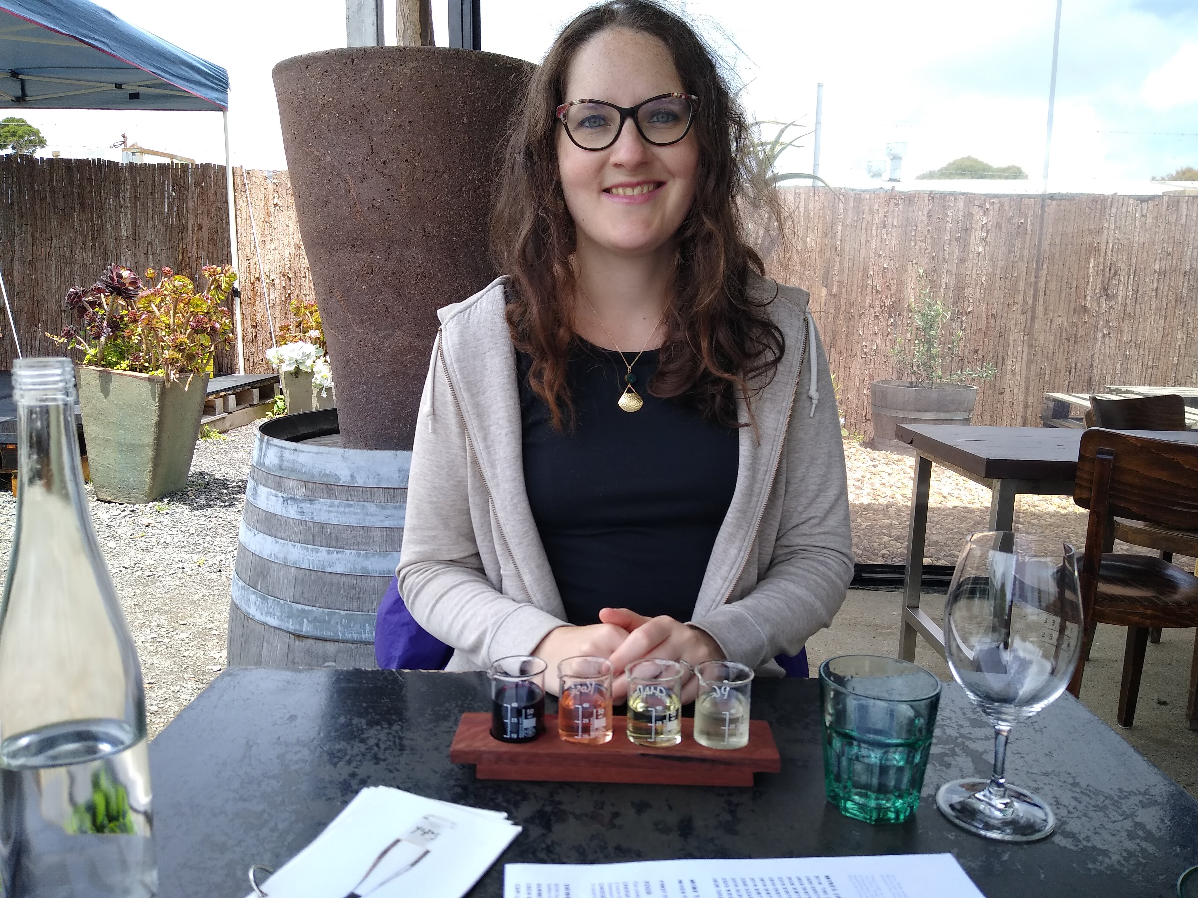 Coralie sits as a table with her hands together.