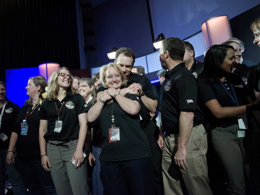 Members of the New Horizons team embracing