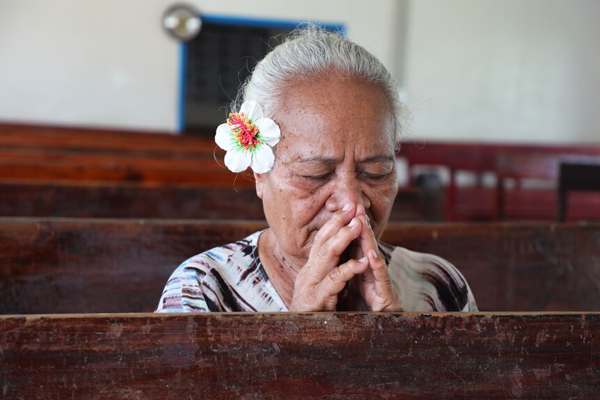 Tineiafi Pedro praying in a church. 