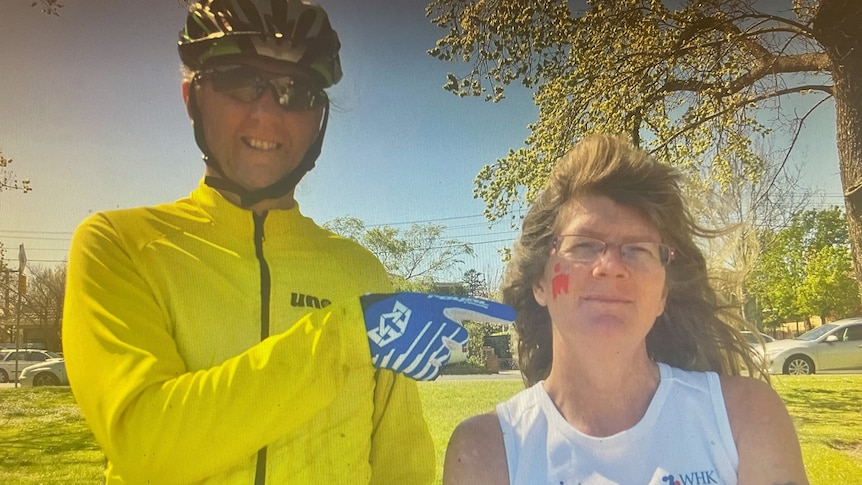 a man in a yellow jacket and a bicycle helmet next to a woman in a white singlet