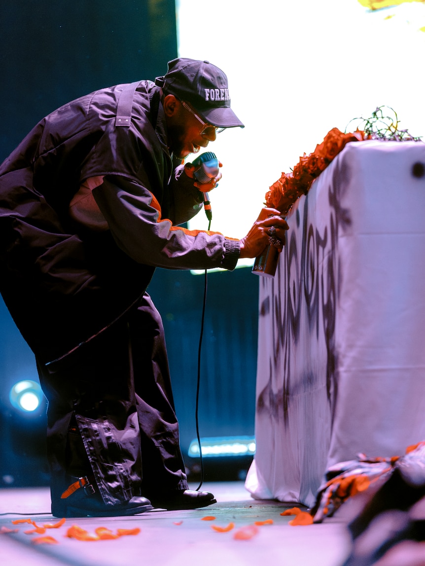 Yasiin Bey (fka Mos Def) spray paints the side of the DJ decks at his Melbourne show for Rising Festival, Sunday 9 June, 2024