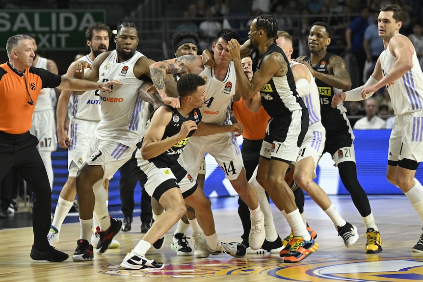 A large group of basketball players clash in an on-court fight