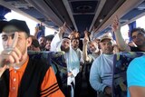 Pro-Palestinian activists sit on a bus after they were deported