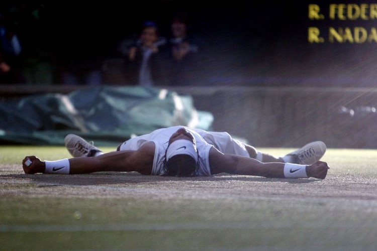Rafael Nadal falls to the ground moments after winning the Wimbledon men's singles final