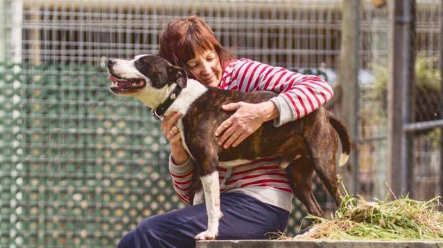 Sue Lopicich hugging a dog