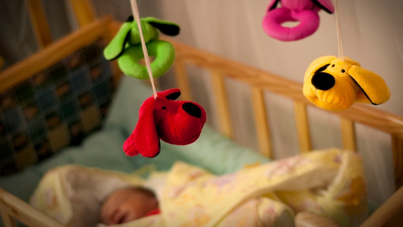 A baby sleeps in a cot