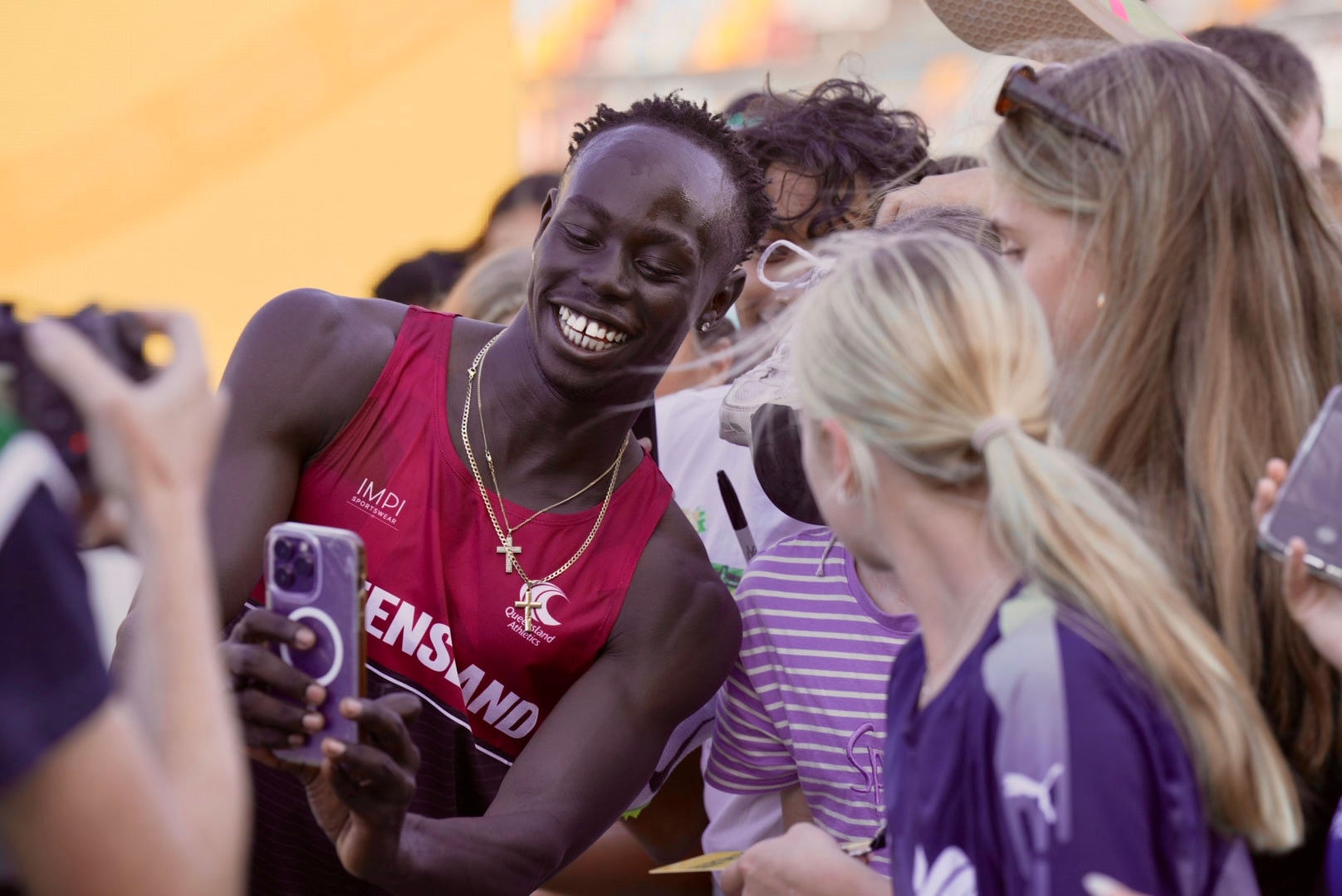 Gout Gout takes a selfie with fans after the 100m at the Australian Athletics Junior Championships.