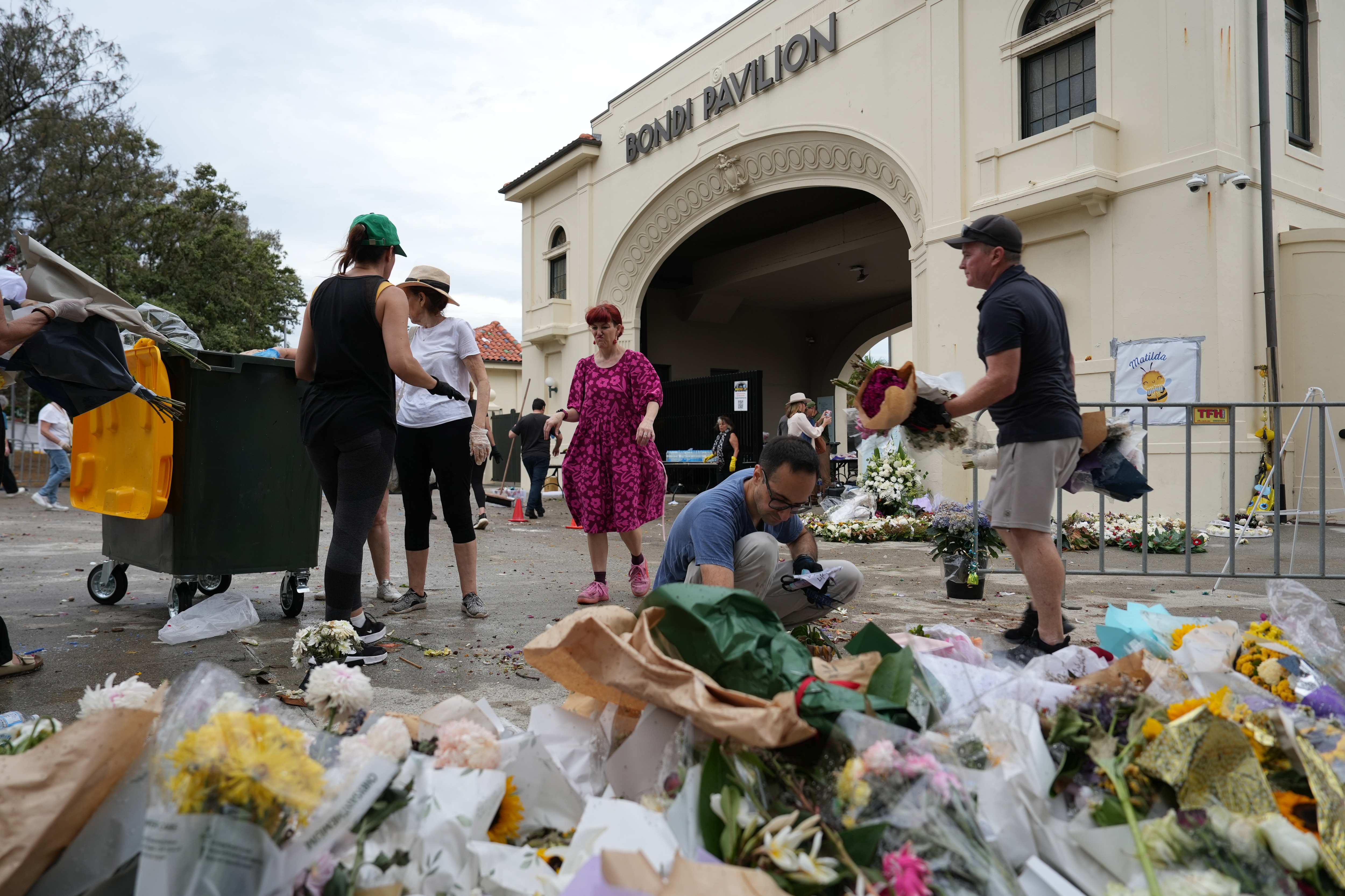 La gente ordena las fotografías fuera del Bondi Pavilion.