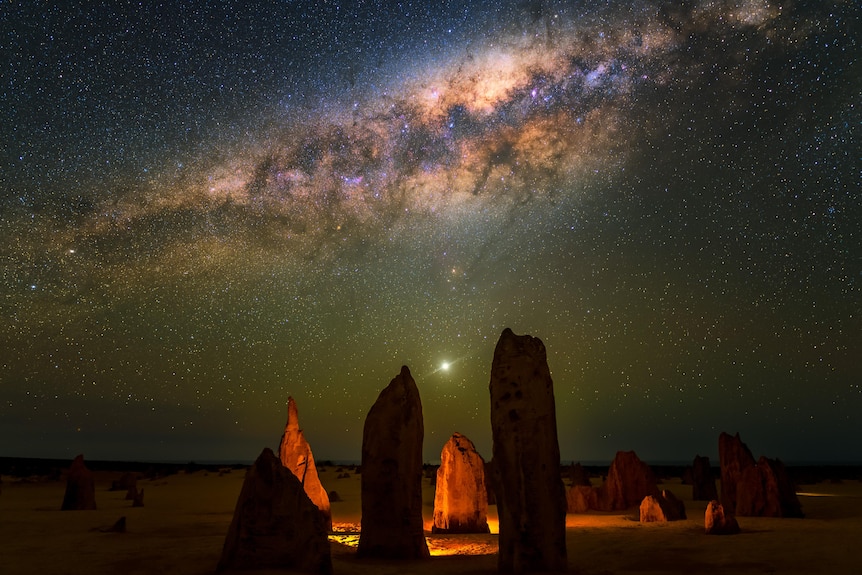 The stars above rocky outcrops in the desert.