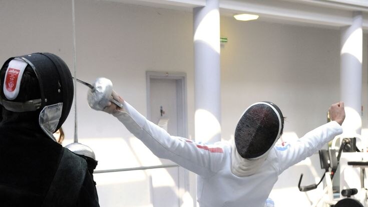 A fencer lunges at an opponent