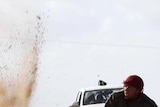 Libya's rebel fighters run away as shrapnel lands near them during heavy shelling near Bin Jawad