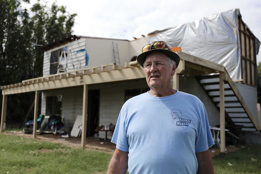 Palmers Island resident Dennis Knock in front of his storm-damaged home