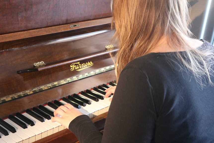 A woman's hands while playing a piano.