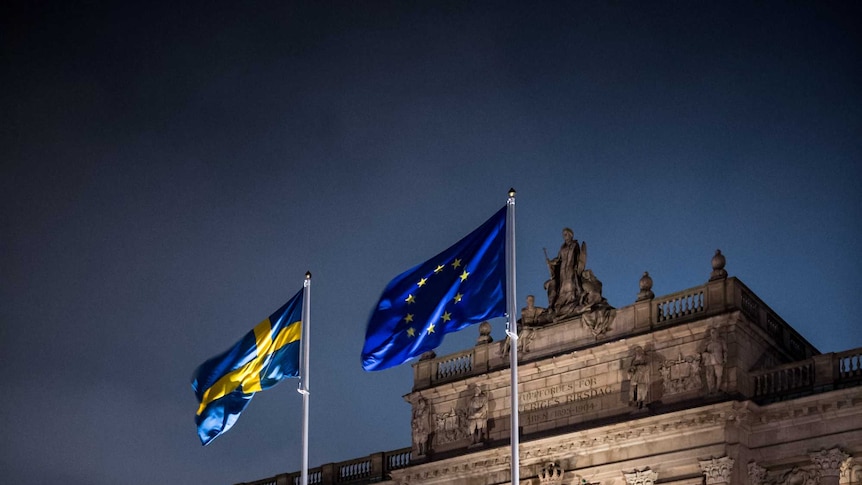 Swedish and EU flag outside the Swedish Parliament