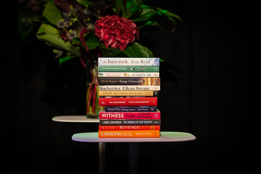 A stack of 12 books sitting on a table