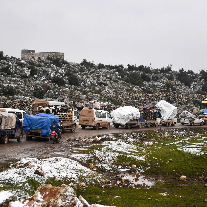 Syrian civilians flee from Idlib in rain toward the north to find safety inside Syria near the border with Turkey.