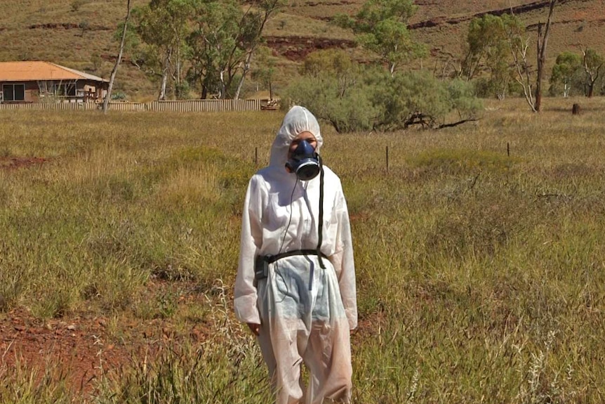 Reporter Melanie Garrick wears a respirator and protective clothing in Wintenoom.