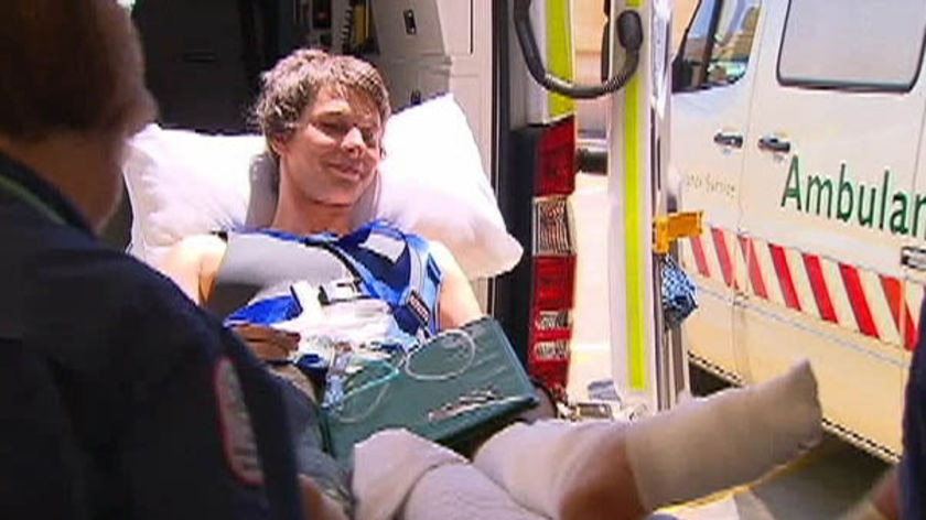 TV still: A young South Australian man is wheeled out of an ambulance after shark attack.
