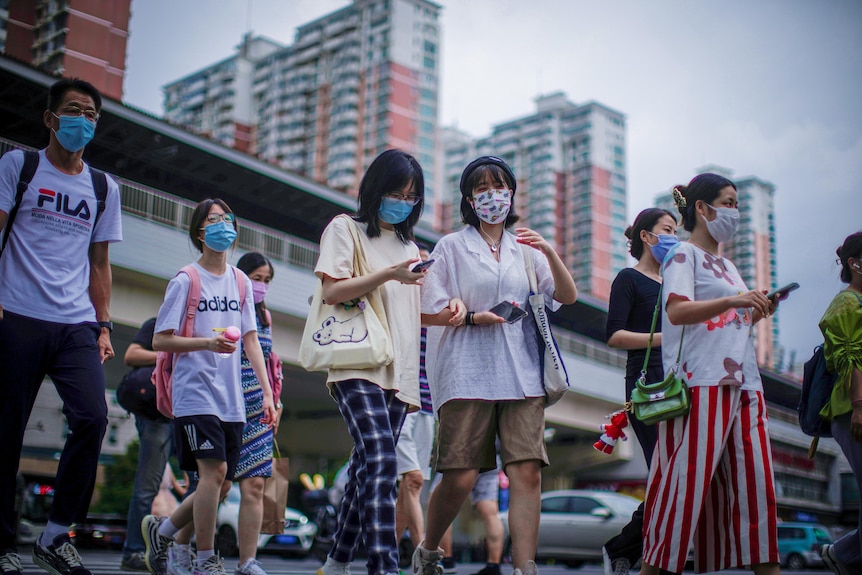 Zatłoczone przejście dla pieszych w Szanghaju, wszyscy noszą maski 