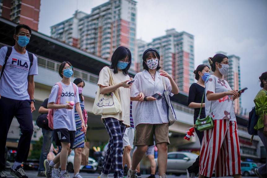 A busy pedestrian crossing in Shanghai with everyone wearing masks 