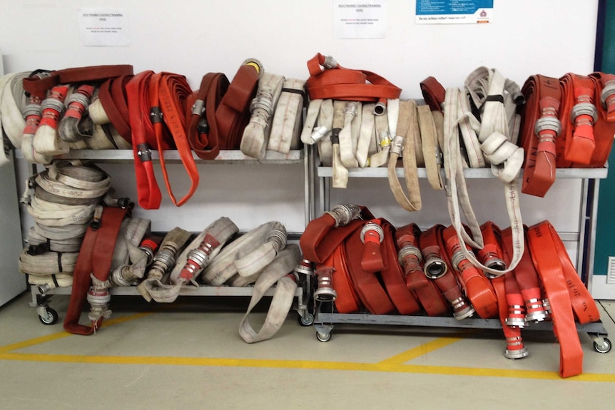 Fire hoses on racks at the Cambridge fire station.