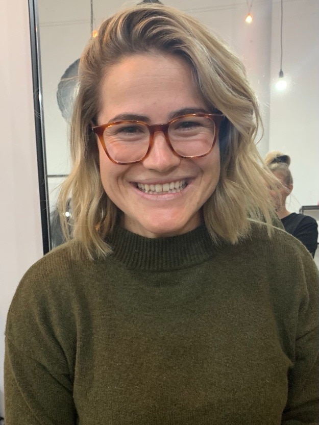 Woman in brown top and glasses smiling