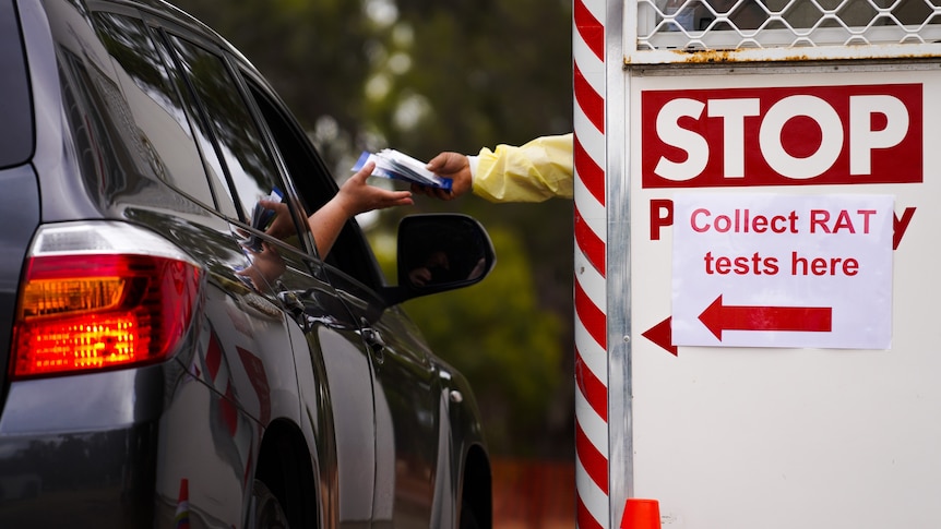 A driver is handed a rapid antigen test.