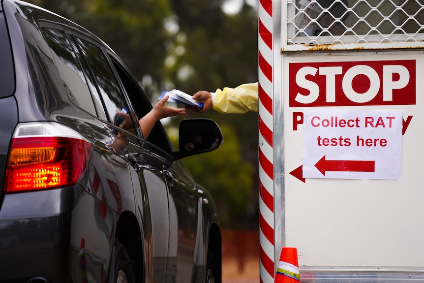 A driver is handed a rapid antigen test.