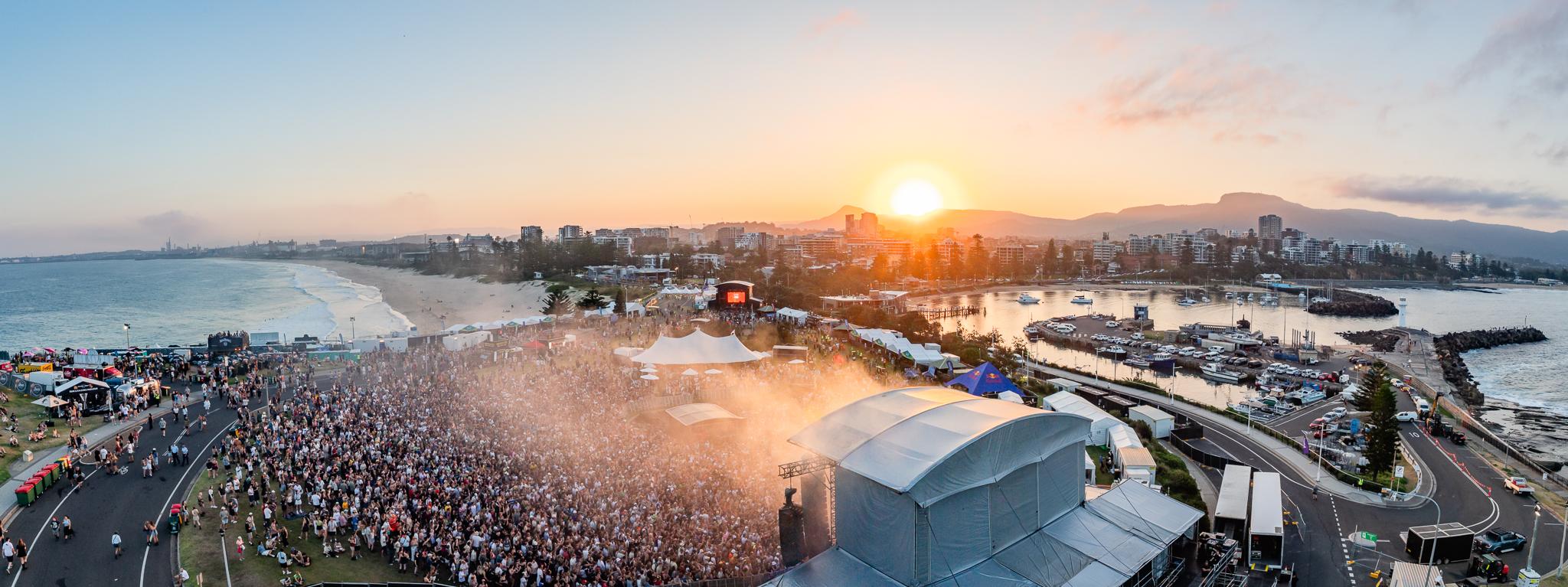 Wide angle photograph of a music festival on a headland in Wollongong at sunset
