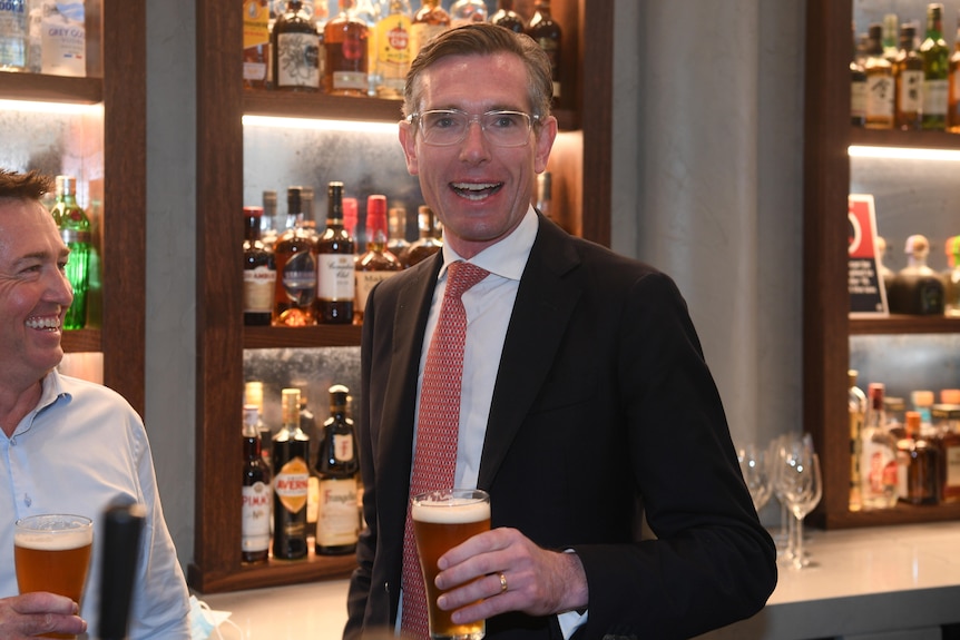 Dominic Perrottet holds a beer 