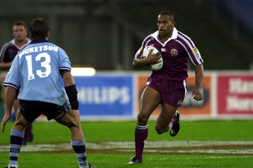 A rugby league player rushes towards an opponent.