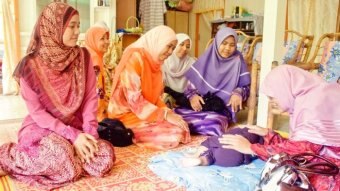 A group of women seeing a baby sleeping