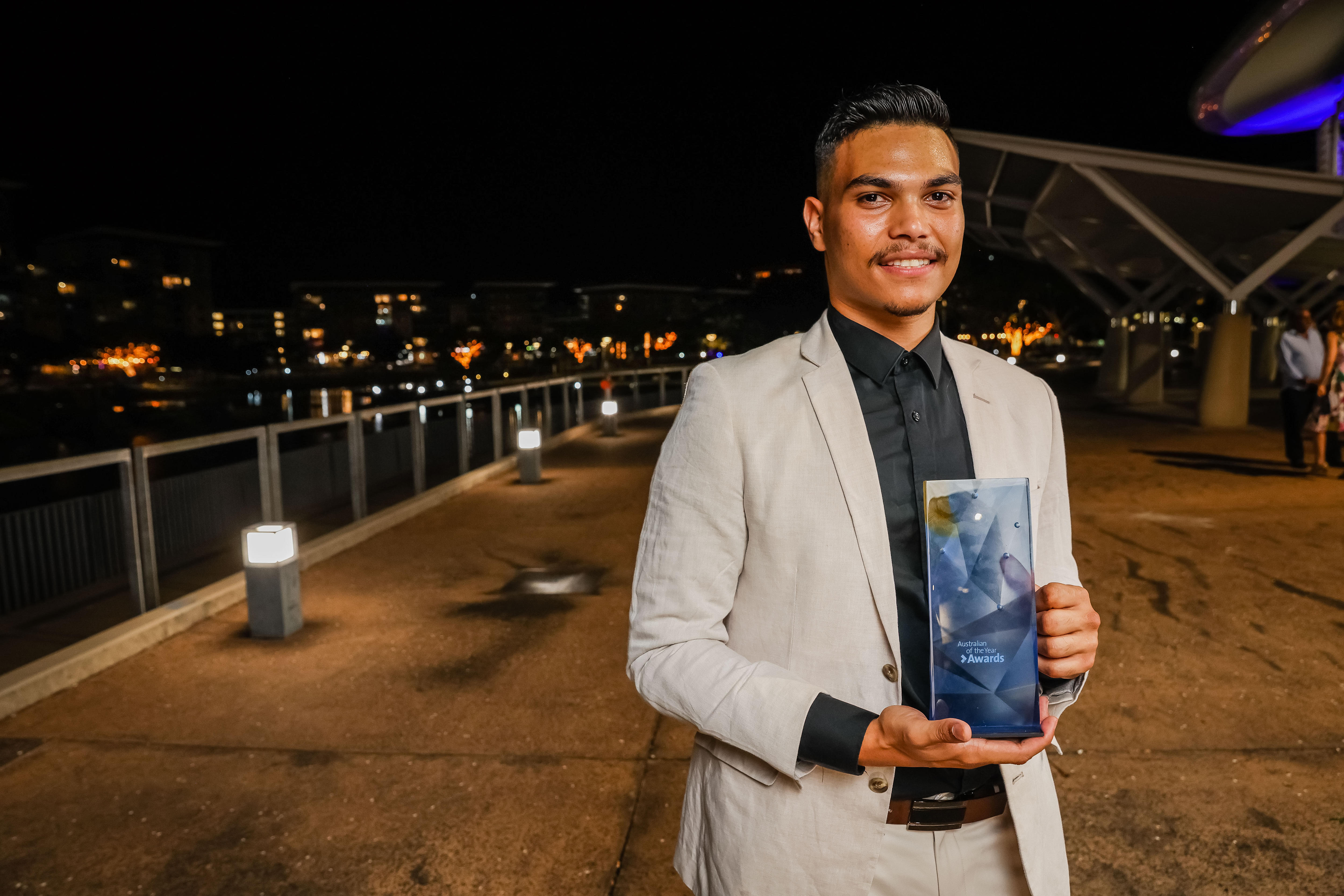 A young man holding his young australian of the year award