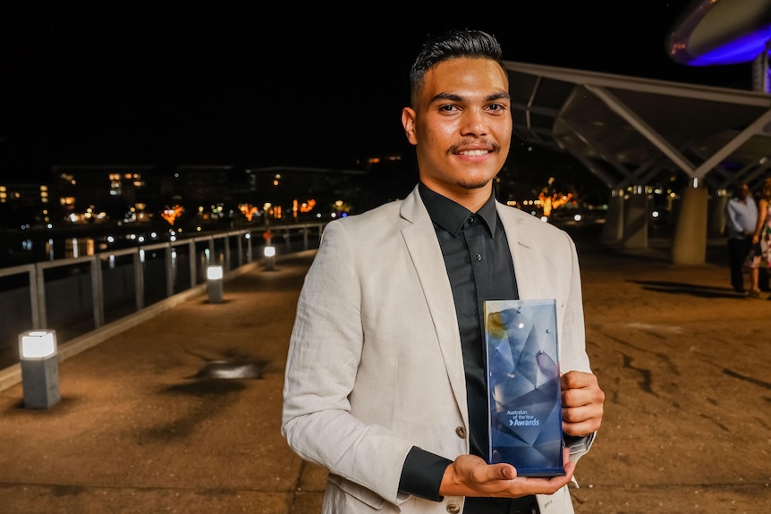 A young man holding his young australian of the year award