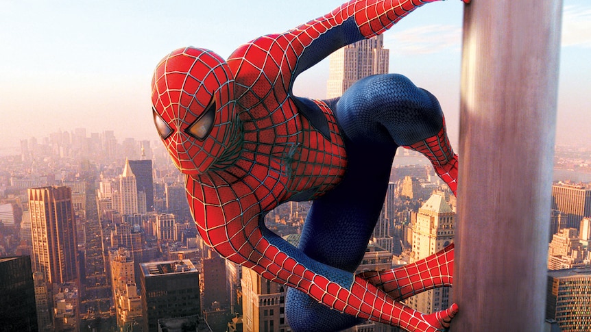 Spider-Man sticks to the outside of a skyscraper in a still from a film.