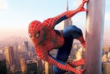Spider-Man sticks to the outside of a skyscraper in a still from a film.