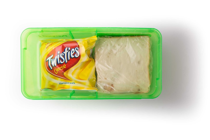 A Nutella sandwich and a packet of Twisties in a clear green lunch box.