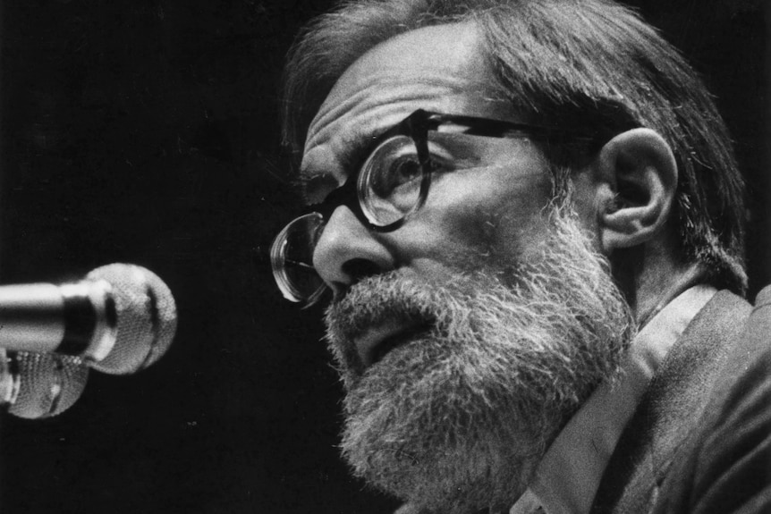 A close up, black and white image of John, who is wearing glasses and has a thick white beard.