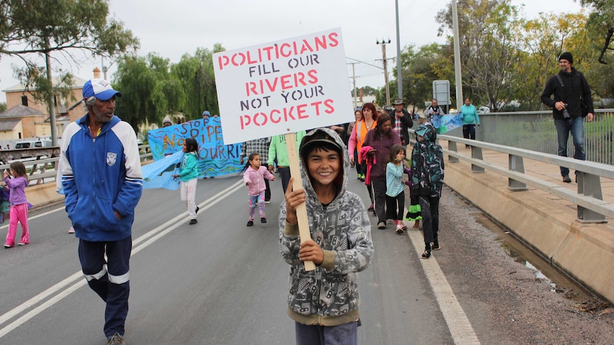 A boy protests in Wilcannia over the state of the Darling River.