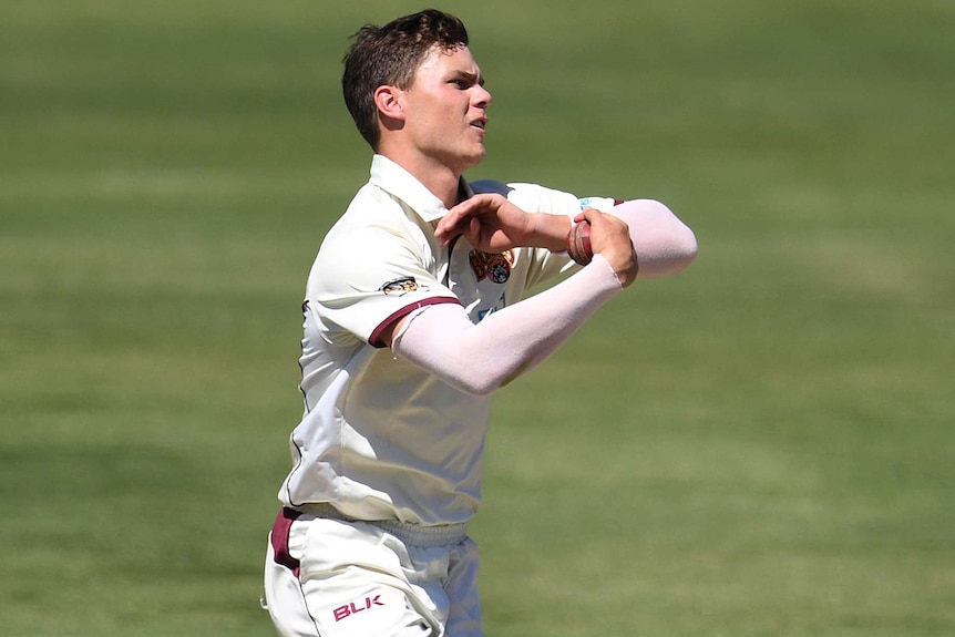 A Queensland leg spinner runs in to bowl against New South Wales in a Sheffield Shield cricket match in Adelaide.