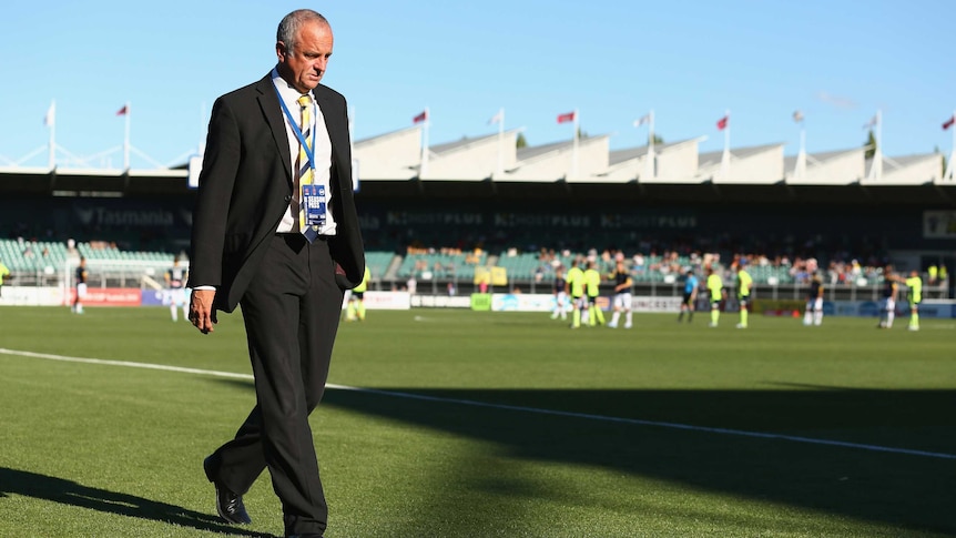Marching orders ... Mariners coach Graham Arnold walks from the ground after he was sent off