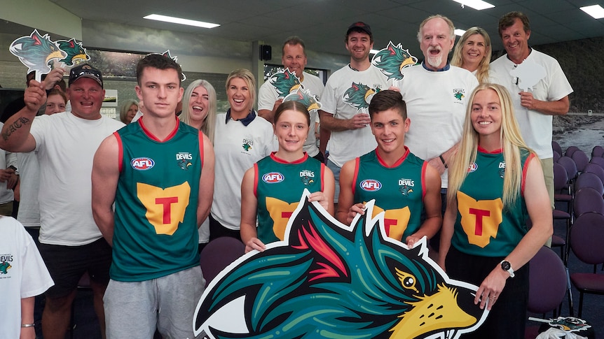 Players wearing the Tasmania Devils foundation guernsey design, surrounded by supporters at Devonport launch event.