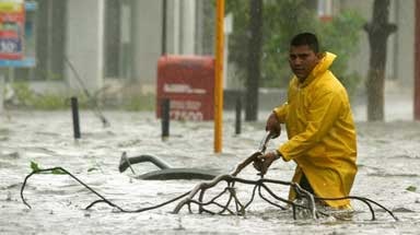 Hurricane Wilma: a man wades through a flooded street at the resort town of Cancun.