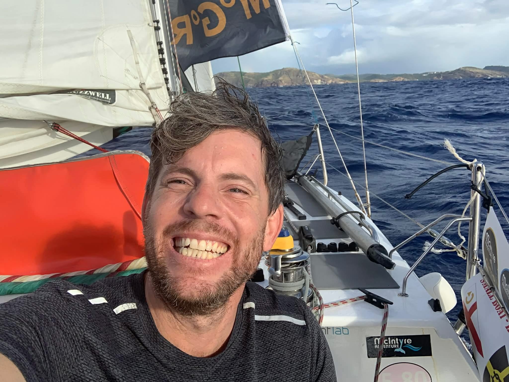 A selfie of a man smiling while on a yacht at sea.