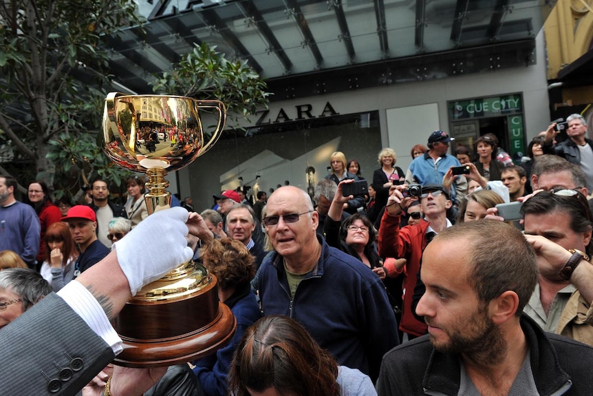 The Melbourne Cup is held above the crowd during the Cup parade in Melbourne on October 31, 2011.