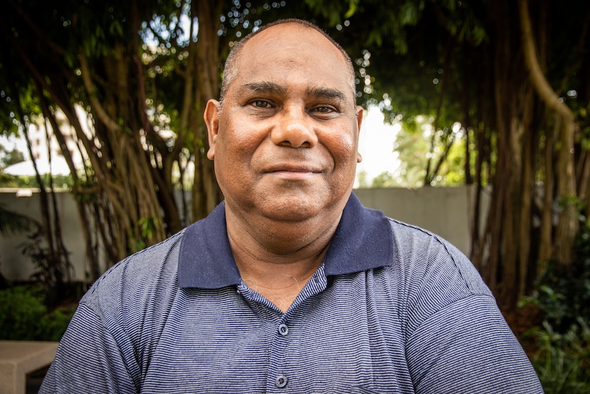 Headshot of man beside in front of a banyan tree.