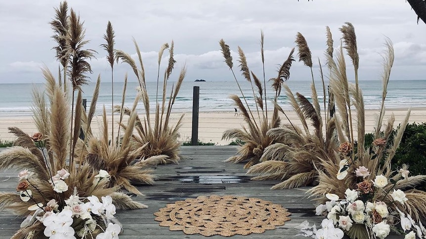 Pampas grass decorations at a wedding at Byron Bay, with Julian Rocks in the distance